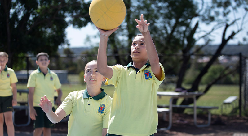 Students playing netball outside at St Angela's Primary School Castle Hill
